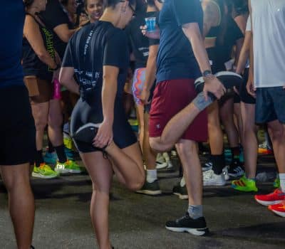 Participantes da LM Run Club alongando antes da corrida no estacionamento da Loja Leal Moreira.